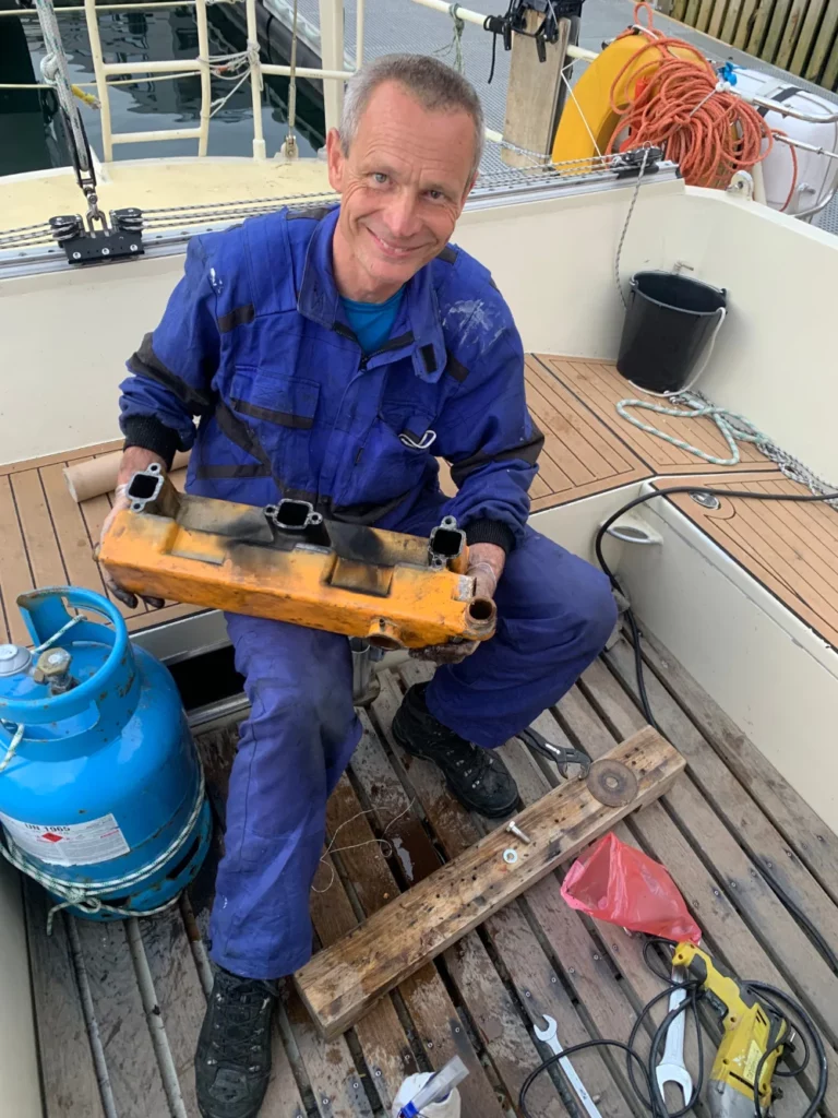 Jiří Zindulka opravuje v přístavu města Tromsø vodní výměník a provádí revizi motorů před vyplutím na Jan Mayen.